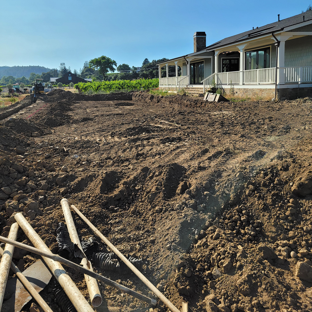 a house with dirt and a building in the background