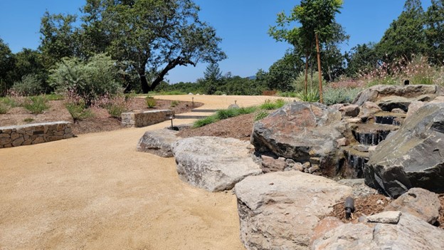 landscaped garden with large rocks and small waterfall