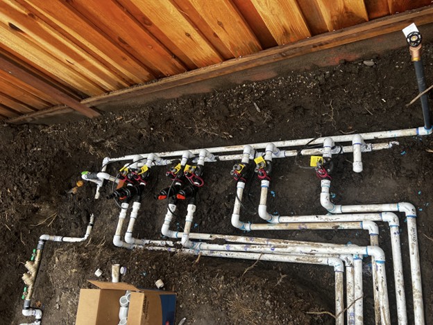 Irrigation valve manifold in process for both drip valves (seen on left with flushable wye filters) and sprinkler valves (seen on right without filters)