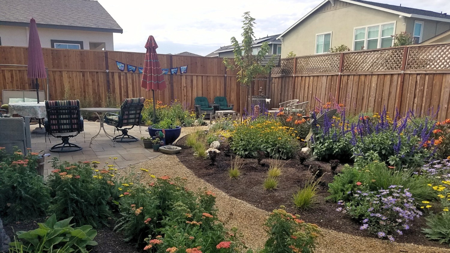 A well-designed backyard landscape with a multitude of colorful flowers.