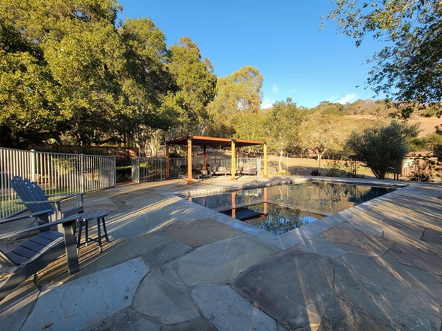 A shady corner of a pool patio created by Inspired Landscapes in Sonoma. One side benefits from the shade of existing Oak trees, while the exposed side utilizes a wooden Pergola.