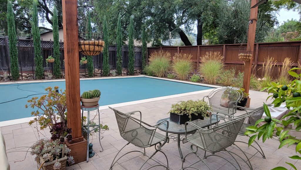 A concrete paver hardscape installed by Inspired Landscapes provides durability for furniture, pots, and high traffic uses in Cloverdale. 