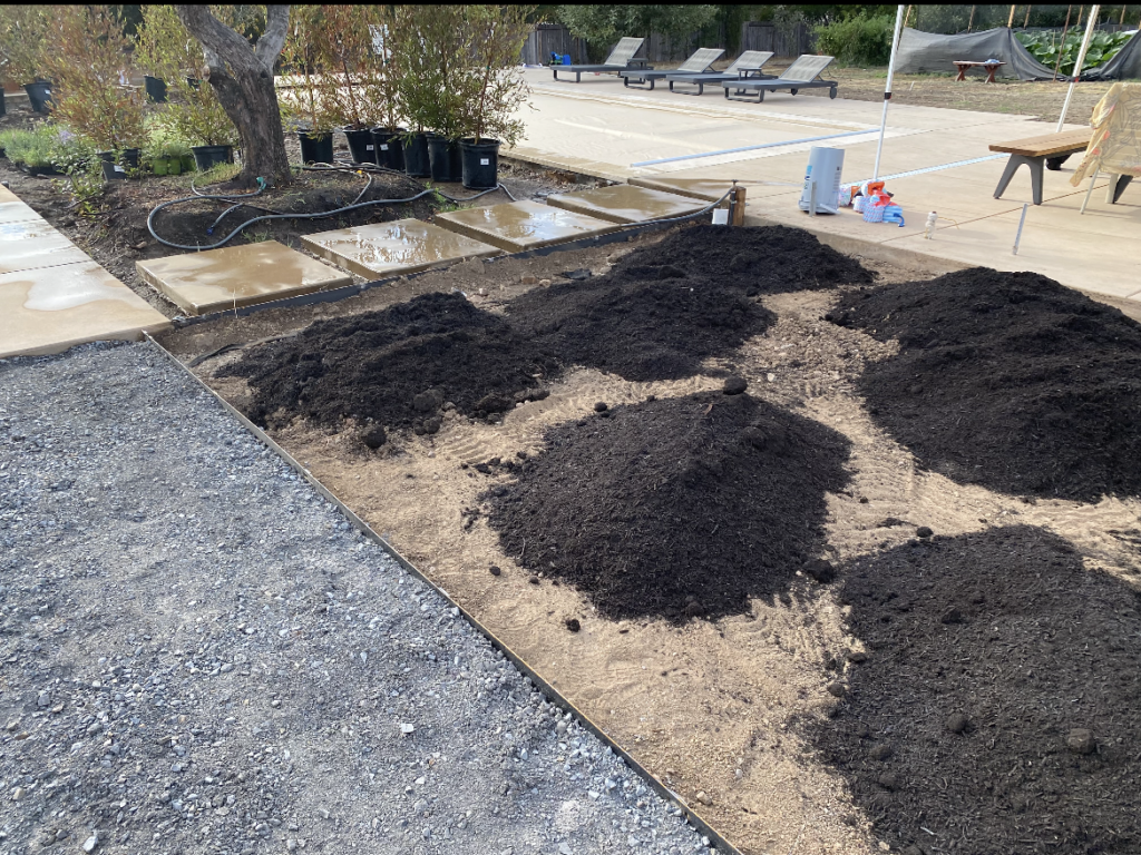Compost piles being added before tilling a compacted sandy clay soil area in Fountain Grove. 